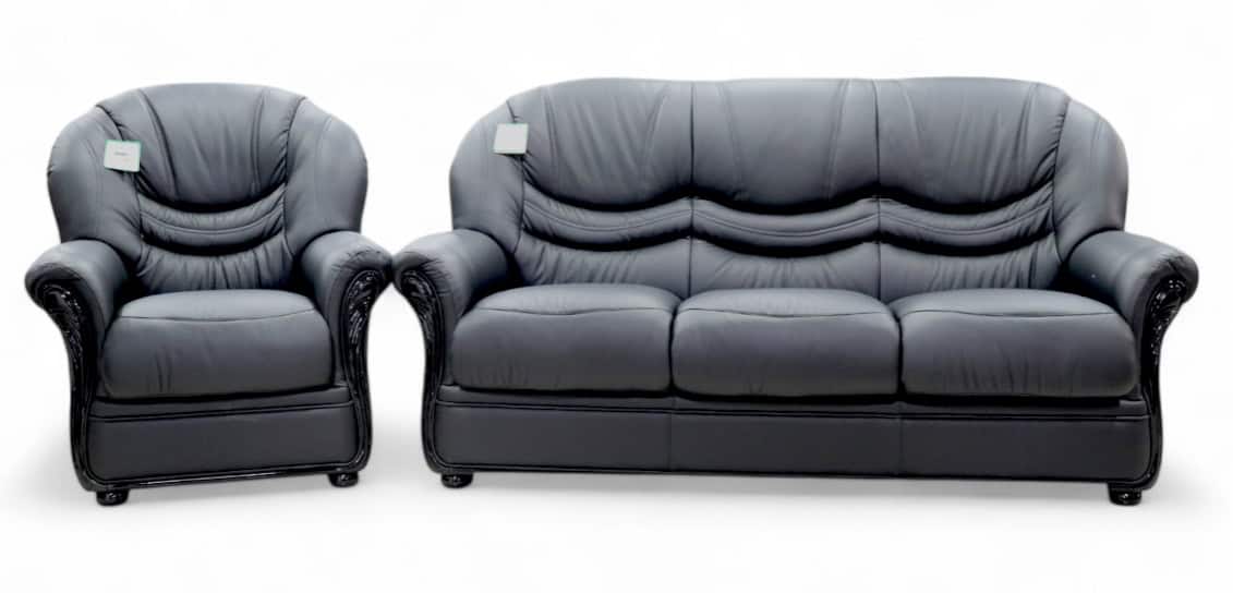A dark grey leather armchair and a matching three-seater sofa.
