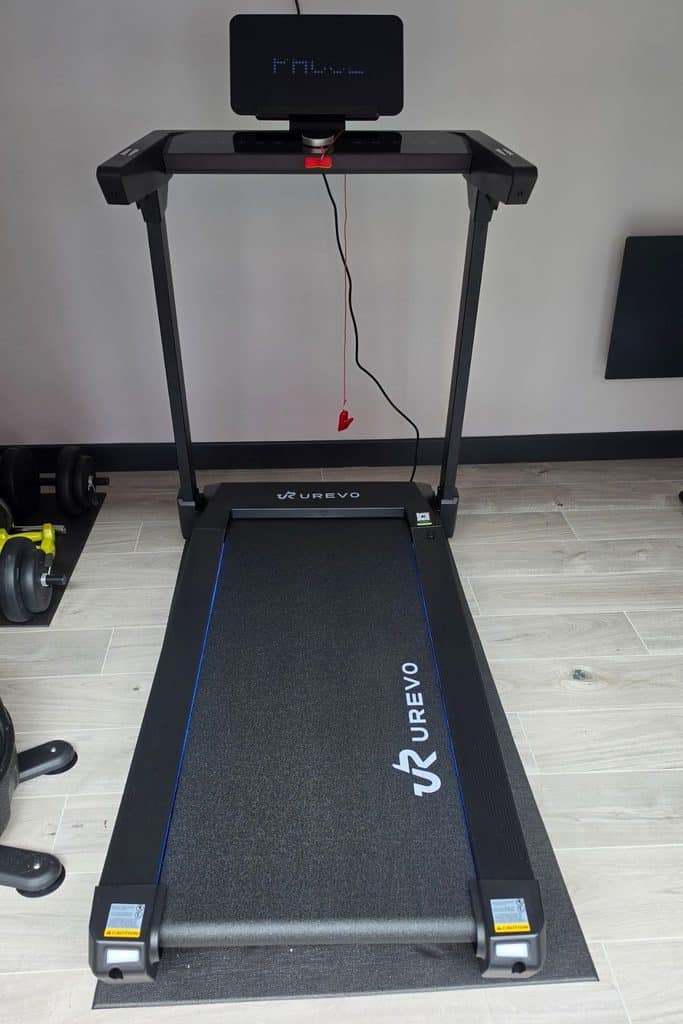 Urevo treadmill with a digital display and safety clip on a rubber mat.