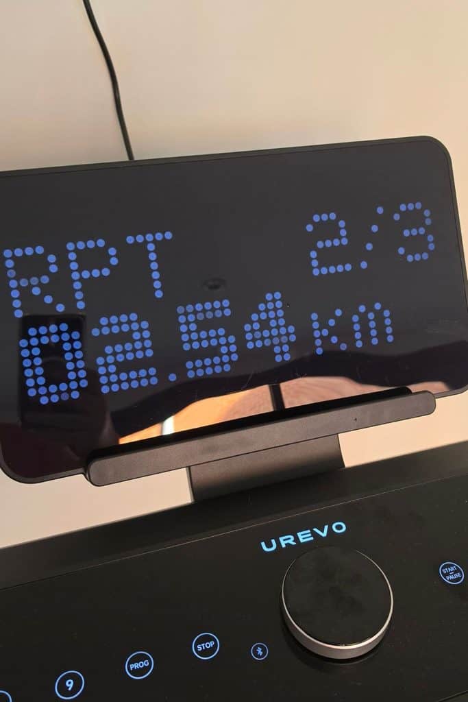 Urevo treadmill console showing “rpt 2/3” and “02. 54 km” on the blue digital display.