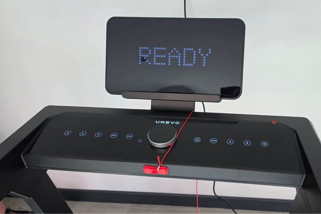 Urevo treadmill console with a digital display reading “ready” and a red safety clip attached to the control panel.